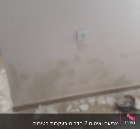 קיר עם כתמי צבע, שברי טיח על הרצפה